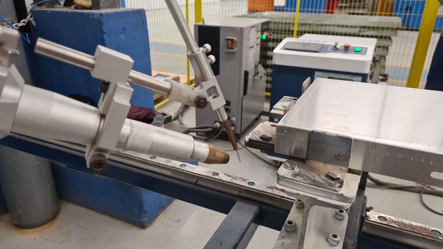 Célula robotizada de soldagem laser com cabeçote, fonte SENFENG, dispositivo e proteção física no ponto de partida